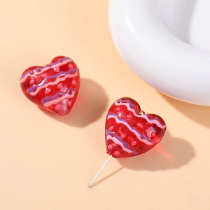 Close-up of heart-shaped glass beads with red and pink polka dot patterns for DIY jewelry