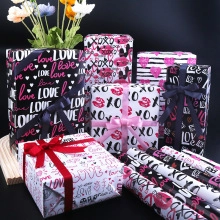 Detail view of assorted Christmas kraft wrapping paper with LOVE and XOXO patterns and ribbons