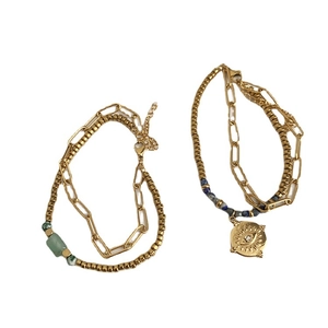 Double-layered gold titanium steel bracelet featuring green beads and evil eye pendant
