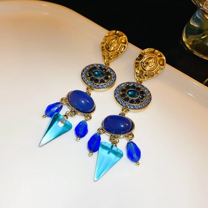Detail von Vintage-Schlangenohrringen in Gold mit blauen Steinen und Strassbesatz