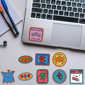 Colorful pop art stickers shown on a laptop and laid out flat with creative phrases