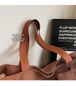 Detail of a brown waffle knit tote bag with durable canvas strap and soft inner lining