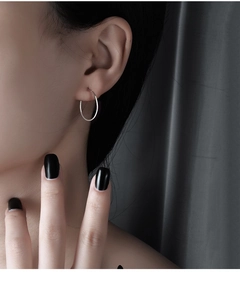 Close-up of minimalist s925 sterling silver hoop earrings worn by a professional model