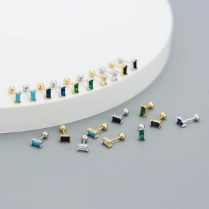 Macro shot of rectangular zircon stud earrings in various colors with gold and silver base