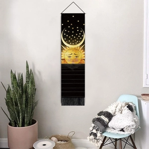 Nordic wall hanging tapestry with gold moon and sun patterns on black fabric with tassels