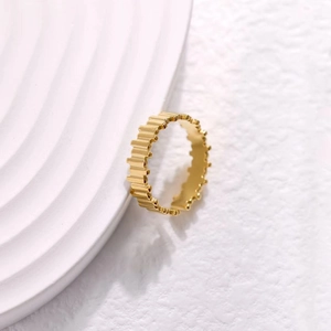 Detailed macro view of the golden serrated gear edge design on this minimalist steel ring