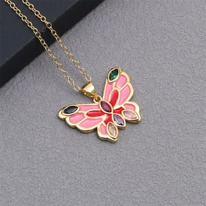 Detail of gold butterfly pendant with colorful gemstones and pink enamel inlay