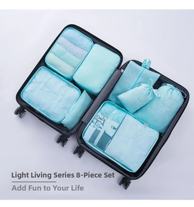 Close-up of 8-piece light blue travel organizer set packed in a black suitcase
