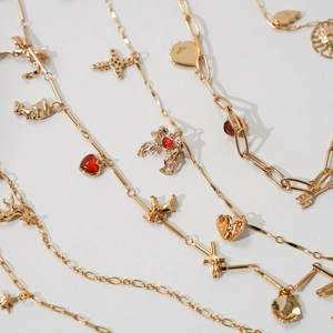 Golden titanium steel necklaces featuring heart, cross and cupid pendants with red stones