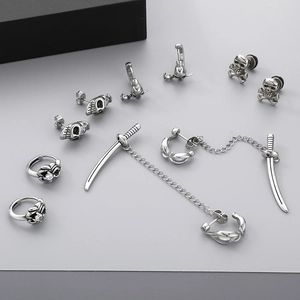 Macro view of gothic skull studs and cross sword earrings with rhinestones in silver