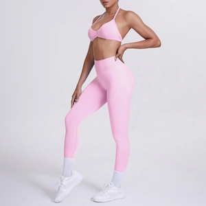 Dettaglio del reggiseno sportivo rosa allacciato al collo e leggings yoga a vita alta