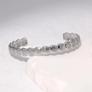 Sleek silver stainless steel open bangle featuring a unique textured scale pattern