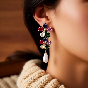 Détail de boucles d'oreilles vintage dorées 18k avec pierres colorées et perles