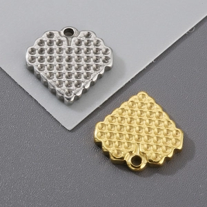 Polished gold and silver heart pendants with pixel texture on grey background