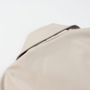 Detail view of the beige trench coat collar showing premium fabric and fine stitching
