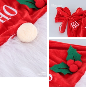 Detail of red velvet Christmas gift bag featuring white HO embroidery and holly leaf decor