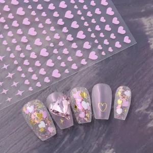 Detail of 3D nail art stickers with pink hearts, gold foil accents and glitter on nails
