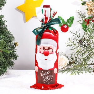 Detailed view of red knitted Christmas wine bottle cover with Santa and Warm Wishes sign