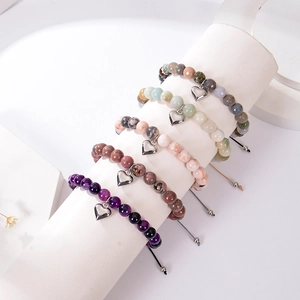Détail de bracelets en perles de pierre naturelle avec breloques cœur sur présentoir