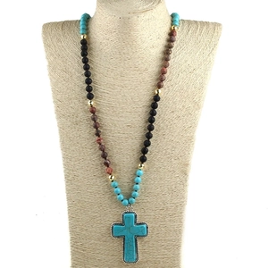 Detail showing 8mm turquoise beaded knot necklace with large turquoise cross pendant