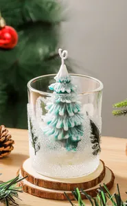 Detailed view of teal Christmas tree scented candle in glass jar with wooden coaster base