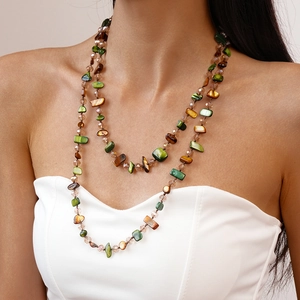 Close-up of double-layer necklace with green and amber irregular stone beads on a model