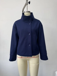 Detail of navy blue cropped coat featuring a high collar and single-breasted button design