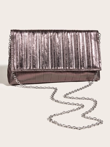 Dettaglio pochette metallica a pieghe con texture verticali e catena in argento