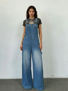 Vue de face de la salopette en jean ample pour femme avec boucles en métal en bleu délavé