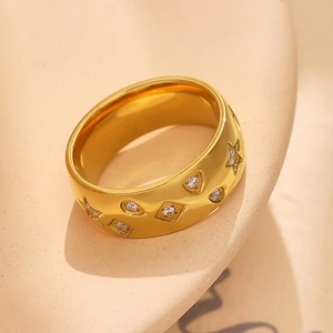 Macro shot of 18k gold plated wide ring with star engravings and inlaid zircon stones