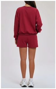Detail view of the wine red sweatshirt set showing back pocket and ribbed hem design