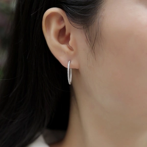 Close-up of double row moissanite hoop earring in silver on model ear