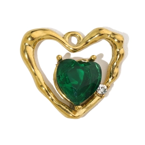 Detail of a gold heart pendant featuring a green gemstone and small white rhinestone
