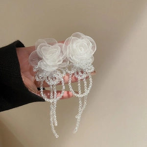Detail showing white mesh flower earring with long hanging crystal bead tassels