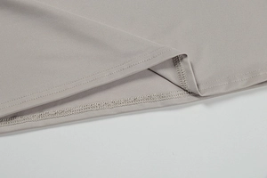 Close-up of double-stitched hem on a grey knit fabric, showing high-quality sewing details
