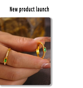 Detail of 18k gold plated ring featuring a rectangular emerald green stone and zircon side