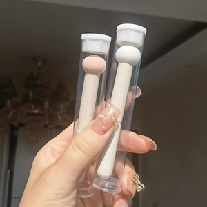Close-up of two mushroom head concealer sponges with wooden handles and clear caps
