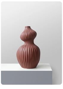 Macro-opname van de terracotta keramische vaas met verticale geribbelde textuur op voet