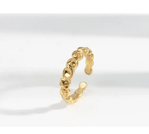 Macro di anello dorato a trama irregolare con finitura martellata su sfondo bianco puro
