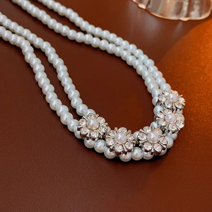 Detail of double-layer faux pearl choker necklace with five floral diamond charms