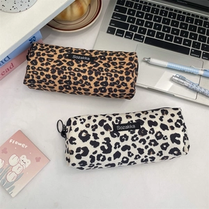 Close-up of vintage leopard print canvas pencil cases with large circular ring zippers