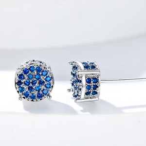 Macro shot of silver hip hop studs featuring micro-paved blue zircons and secure four-claw setting