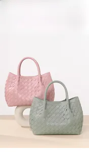 Detail of hand-woven mini bucket bags in pink and sage green with soft leather texture