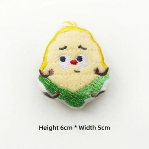 Detail of 6x5cm cartoon corn plush brooch with cute embroidery on white background