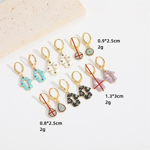 Golden arrow drop earrings with colorful zircon and evil eye designs on white background