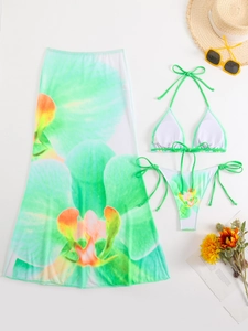 Detail view of the green floral print on the 3-piece bikini set and sheer mesh sarong