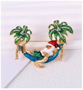 Detailed view of Santa Claus relaxing on a rhinestone-studded palm tree hammock brooch
