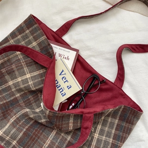 Detail of plaid tote bag showing brown checkered fabric and burgundy lining texture