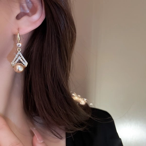 Vintage gold triangle drop earrings with sparkling crystals and pearl on a female model