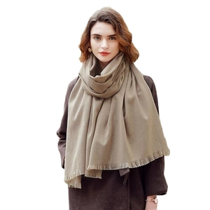 Elegant beige cashmere-feel shawl with fringe trim on a model for winter warmth